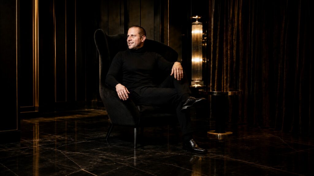 Barry Roberts Three-quarter portrait in a black wing chair